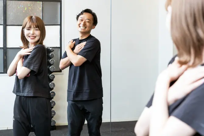上半身のストレッチをする女性とトレーナーの写真