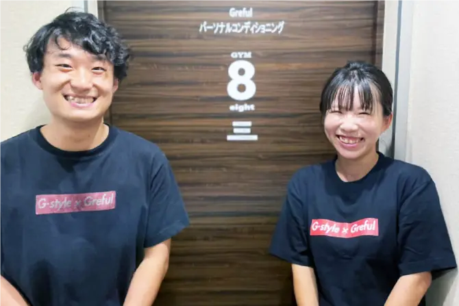 トレーニングルームの前に立つトレーナーと女性の写真
