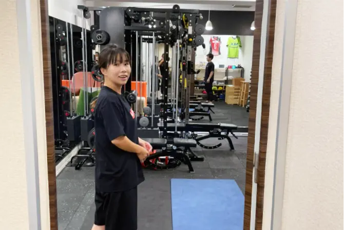 トレーニングルームに入ろうとする女性の写真