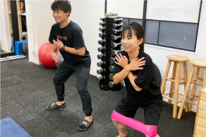 チューブを使ったトレーニングを受ける女性の写真